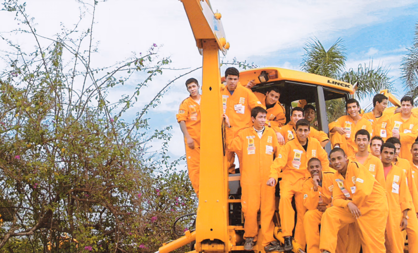 Turma do Projeto Pescar em frente a uma retroescavadeira Linck